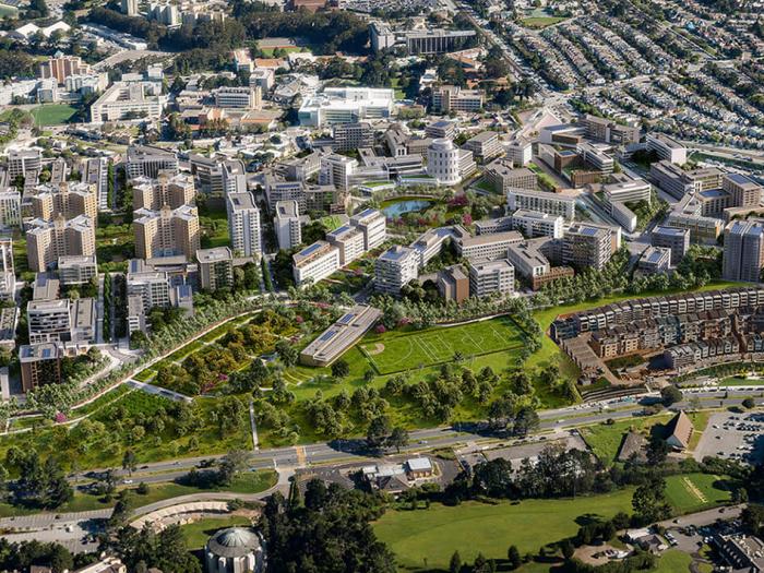 A bird's-eye view rendering of the Parkmerced project, showing a mix of existing low-rise housing and proposed modern glass towers interspersed with landscaped parks, walking paths, and athletic fields.