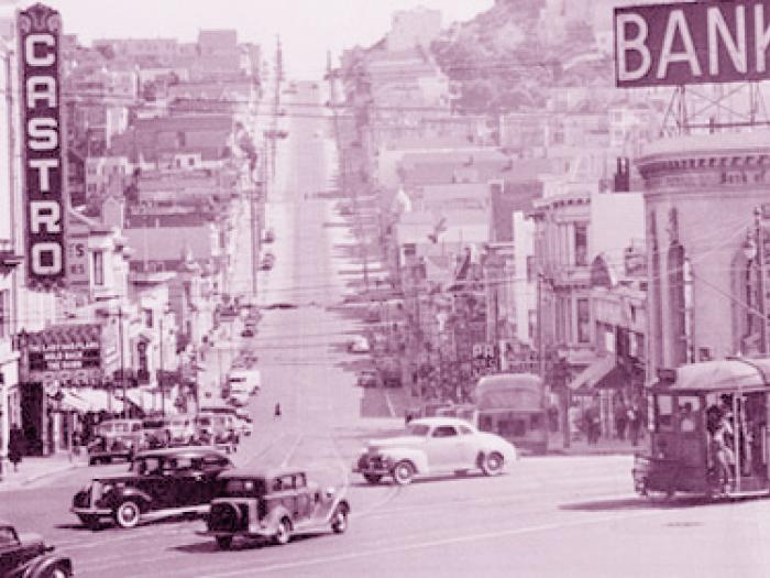 Historic panoramic view of Eureka Valley and the Castro neighborhood, showing a dense hillside of homes and buildings under a bright sky with the city stretching into the distance.