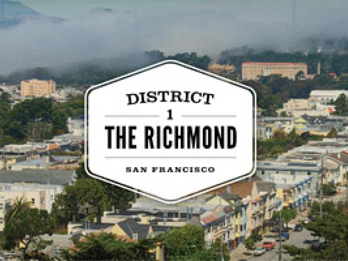 A graphic illustration with a central white badge featuring the text DISTRICT 1 THE RICHMOND SAN FRANCISCO, set against a landscape view of a residential neighborhood with dense rows of houses and greenery.