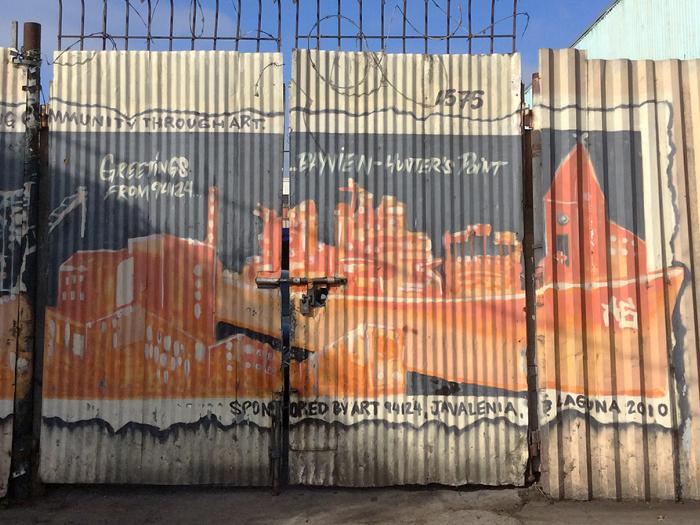 corrugated fence with painting of Bayview industrial buildings