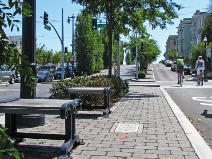 cyclists along one side of pedestrian median with street on other side